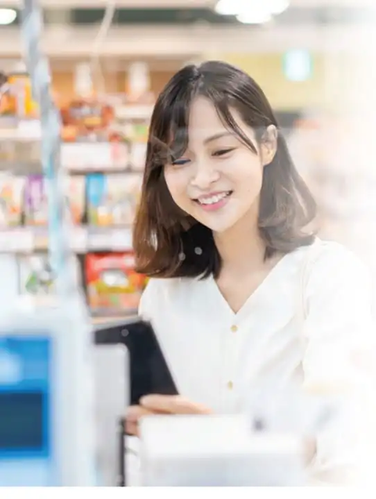 Smiling woman using smartphone in retail store